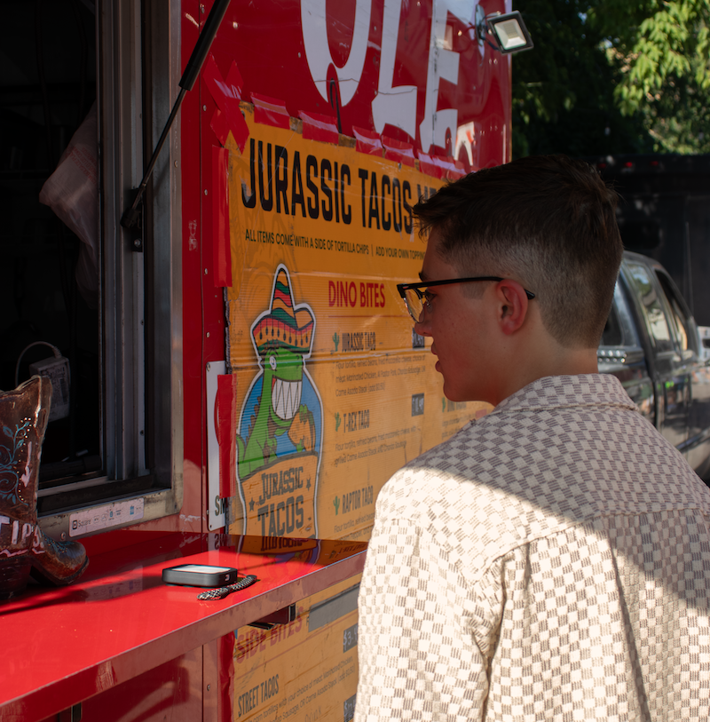 Someone stands at the window of a red food truck.